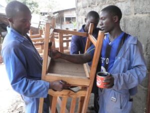 Apprentis menuisiers de Goma vernissant une chaise